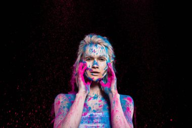 moda kız pembe ve mavi holi toz, siyahta izole poz