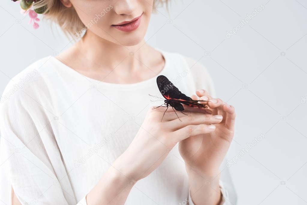 cropped view of girl with beautiful butterfly on hands, isolated on grey
