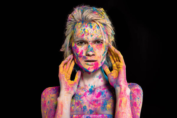 portrait of girl posing in colorful holi powder, isolated on black