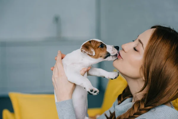 Woman kissing puppy — Stock Photo, Image