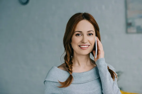 Atractiva Mujer Sonriente Hablando Por Teléfono Inteligente Mirando Cámara Casa — Foto de Stock