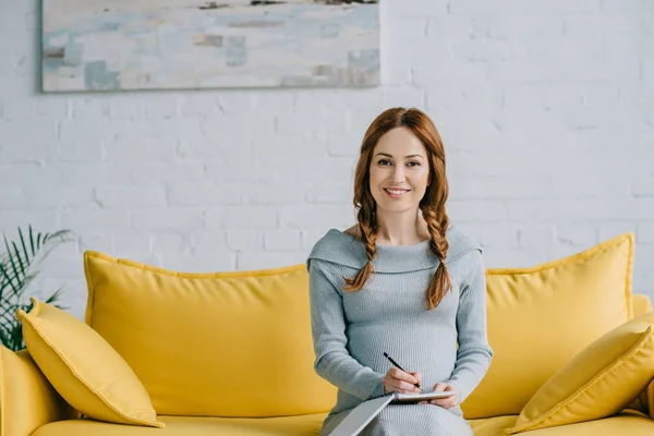 Sorrindo Mulher Grávida Escrevendo Algo Para Notebook Olhando Para Câmera — Fotografia de Stock