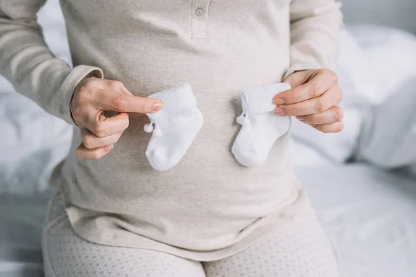 Cropped Image Pregnant Woman Touching Belly Newborn Shoes Bedroom — Stock Photo, Image