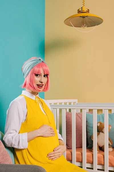 Szczęśliwy Ciąży Szałowy Kobieta Różowe Włosy Dotykając Brzuch Patrząc Kamery — Darmowe zdjęcie stockowe