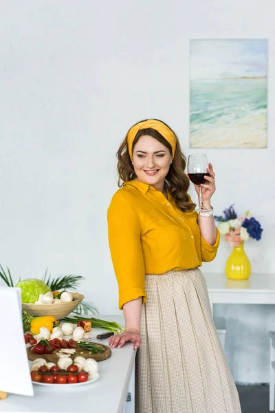 Belle Femme Tenant Verre Vin Regardant Les Légumes Dans Cuisine — Photo gratuite