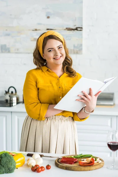 Lachende Mooie Vrouw Houden Receptenboek Camera Keuken Kijken — Stockfoto