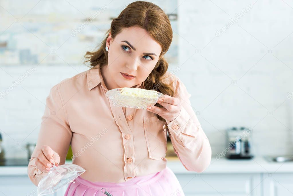 beautiful woman sniffing butter in kitchen