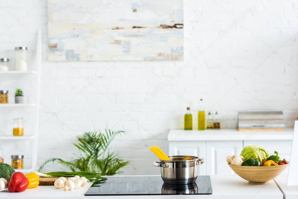 interior of modern light kitchen with paint on wall and electric stove