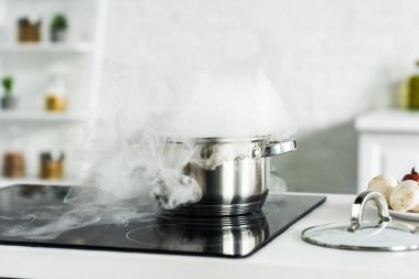 steam over pan on electric stove in kitchen clipart