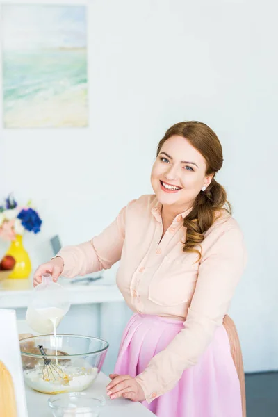 Wanita Cantik Tersenyum Menuangkan Susu Dalam Mangkuk Dengan Tepung Dapur — Stok Foto