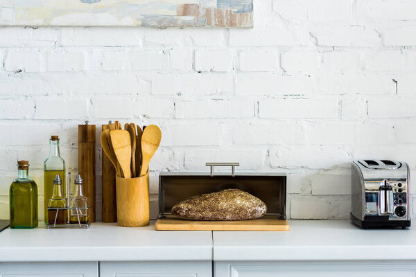 bread in breadbasket and toaster on kitchen counter