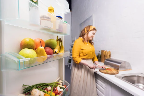 Bela Mulher Cortar Legumes Cozinha Com Geladeira Primeiro Plano — Fotografia de Stock