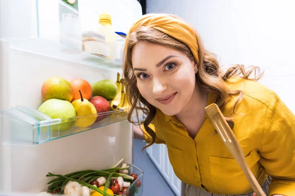 Hermosa Mujer Abriendo Nevera Sosteniendo Espátula Madera Cocina — Foto de Stock