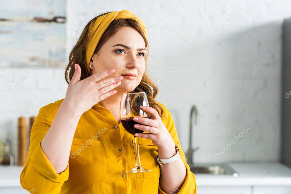 beautiful woman smelling red wine in kitchen