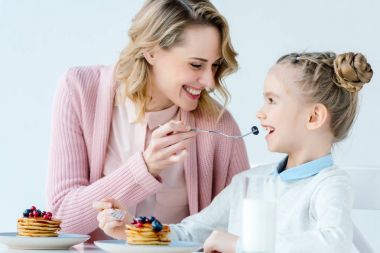 mutlu anne ve kızı masada birlikte kahvaltı