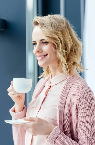 一杯のコーヒーと笑顔の思慮深い女性の側面図 — ストック写真