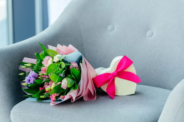 Nahaufnahme Von Verpackten Blumenstrauß Und Herzförmige Geschenkbox Mit Band Auf — Stockfoto