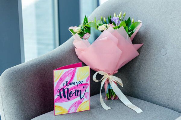 крупным планом вид завернутого букета цветов и я люблю тебя поздравительная открытка на кресле, концепция Дня матери
