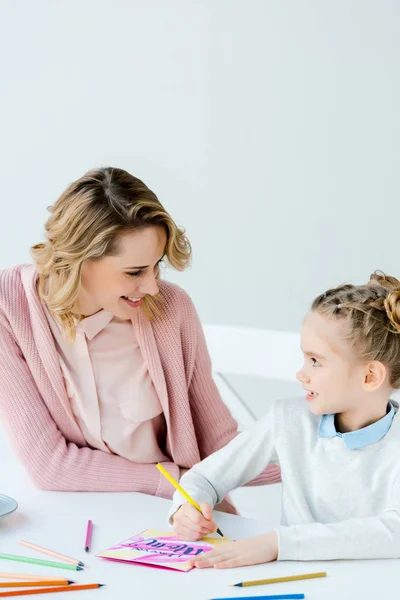 Lachende Moeder Dochter Maken Groet Briefkaart Aan Tafel Kijken — Stockfoto