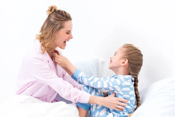 Leende Mor Kittlande Lycklig Dotter Sängen Hemma — Stockfoto