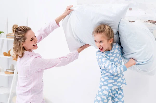妈妈和女儿尖叫着玩乐 在家里和枕头打架 — 图库照片