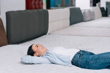Customer lying on orthopedic mattress clipart