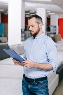 Not Defteri ile düzenlenen minder Mobilya Mağazaları ile odaklı tezgâhtar portresi