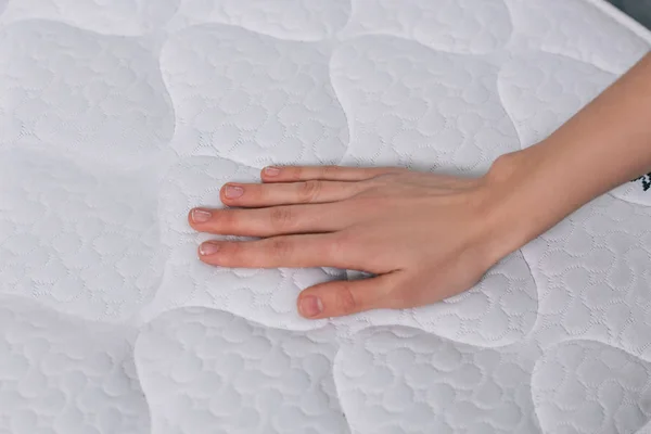 Touching orthopedic mattress — Stock Photo, Image