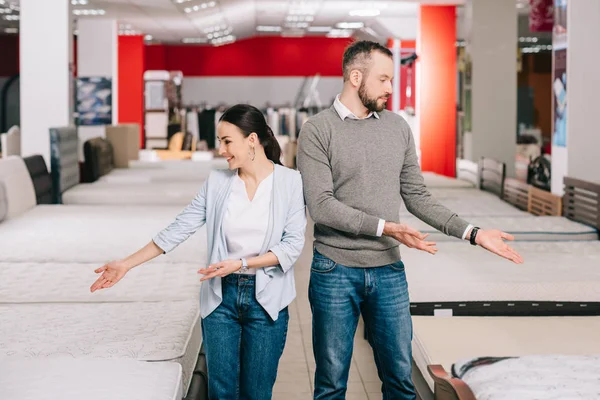 Couple pointing at mattresses — Stock Photo, Image