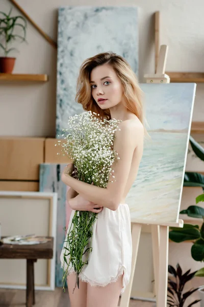 Piękna Młoda Kobieta Nagi Gospodarstwa Kwiaty Białe Patrząc Kamery Studio — Zdjęcie stockowe
