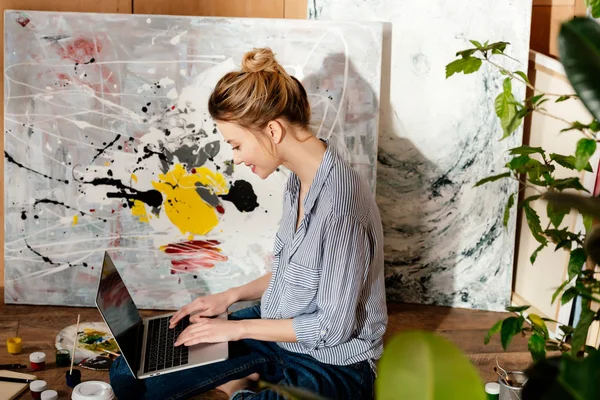 Vista Lateral Sorrir Jovem Pintora Usando Laptop Estúdio Arte — Fotografia de Stock