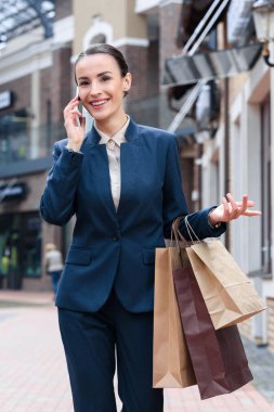 çekici işkadını Smartphone ile konuşmak ve alışveriş torbaları tutan el hareketi