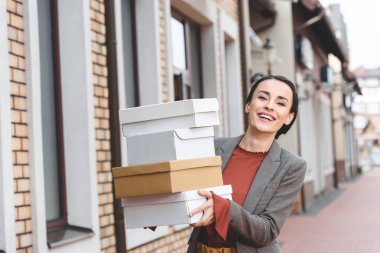 laughing attractive woman holding shopping boxes clipart