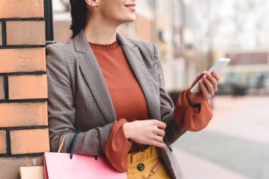 smartphone ve alışveriş torbaları tutan kadın kırpılmış görüntü