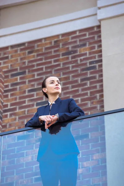 Χαμηλή Γωνία Θέα Όμορφη Επιχειρηματίας Στέκεται Στο Μπαλκόνι Και Αναζητούν — Δωρεάν Φωτογραφία