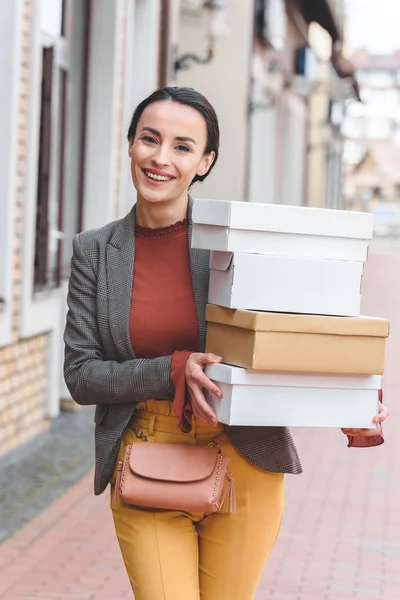 Donna Attraente Sorridente Che Tiene Scatole Della Spesa Guarda Fotocamera — Foto stock gratuita