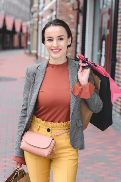 Atractiva Mujer Sosteniendo Bolsas Compras Hombro Mirando Cámara — Foto de stock gratis