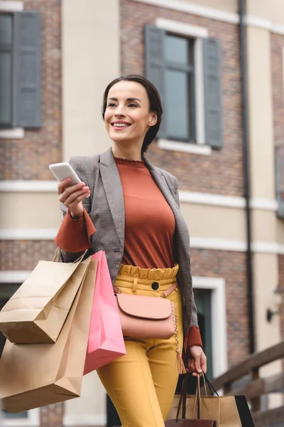 Atrakcyjna Kobieta Trzymając Zakupy Torby Papierowe Smartphone — Zdjęcie stockowe