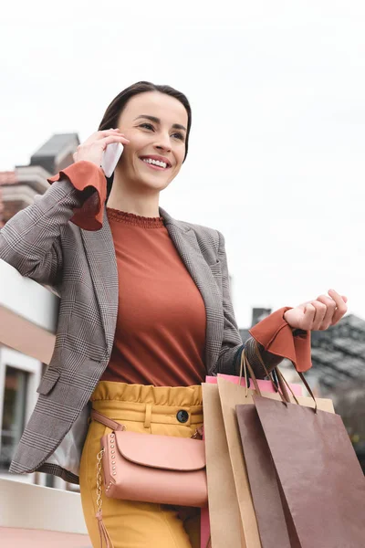 Vista Ángulo Bajo Mujer Atractiva Sosteniendo Bolsas Compras Hablando Por —  Fotos de Stock