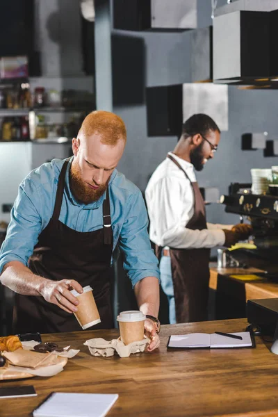 Lachende Afro Amerikaanse Mannelijke Barista Met Koffiemachine Collega Papier Kopjes — Stockfoto