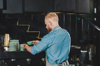 Dikiz genç erkek barista kahve kupa dökme 