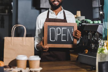 Afro-Amerikan barista işareti kafede açık tutan gülümseyerek in atış kırpılmış