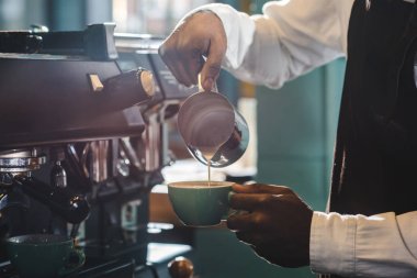 cropped shot of barista preparing cappuccino in coffee shop  clipart
