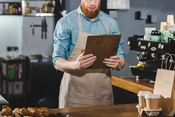 Cropped Shot Serious Young Bearded Barista Holding Clipboard Coffee Shop — Free Stock Photo