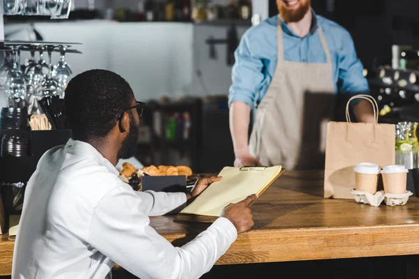 African American Client Holding Blank Clipboard Looking Bearded Barista Coffee — Stock Photo, Image