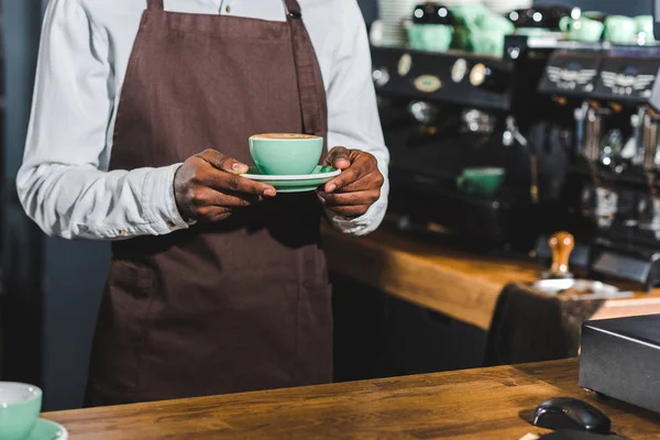 Bijgesneden Schot Van Afro Amerikaanse Barista Holding Kopje Cappuccino Coffeeshop — Gratis stockfoto