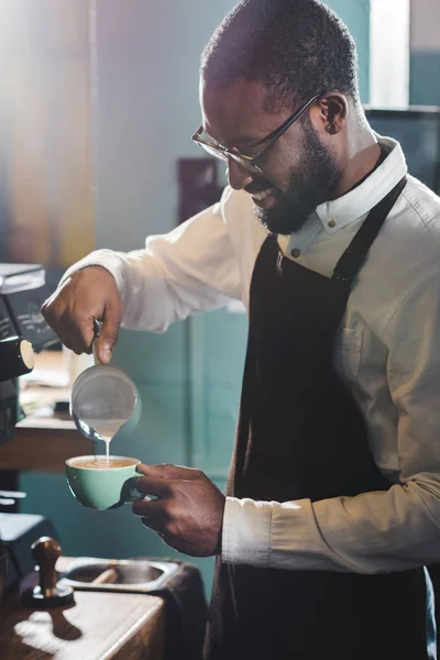 Sorridente Giovane Barista Afroamericano Occhiali Versando Latte Mentre Faceva Cappuccino — Foto Stock