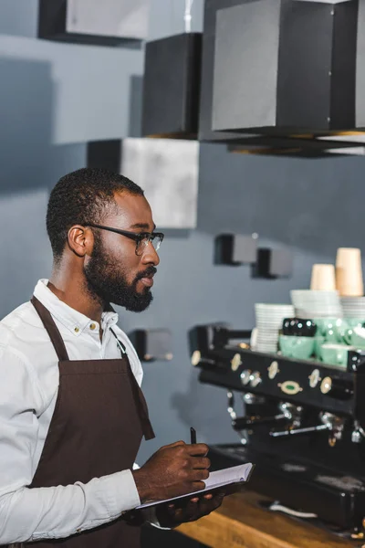 Sidovy Unga Afroamerikanska Barista Glasögon Anteckningar Medan Arbetar Kafé — Gratis stockfoto