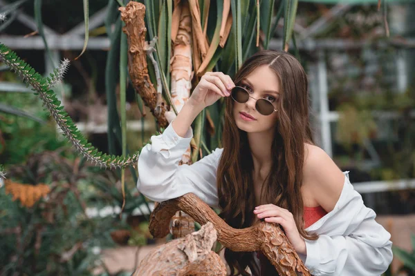 Attraktive Frau Mit Trendiger Sonnenbrille Posiert Tropischen Garten — kostenloses Stockfoto