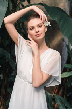 çekici ihale kız saç çiçekli beyaz elbisenin içinde poz 